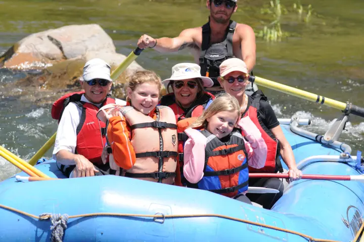 group of children and family smiling in raft