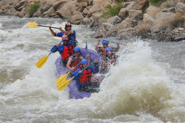 group rafting down splashing rapids